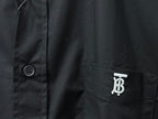 Long-sleeve button-up shirt detail: chest pocket with logo and round button