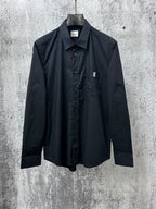 Long-sleeve button-up shirt, dark with pointed collar and chest logo patch
