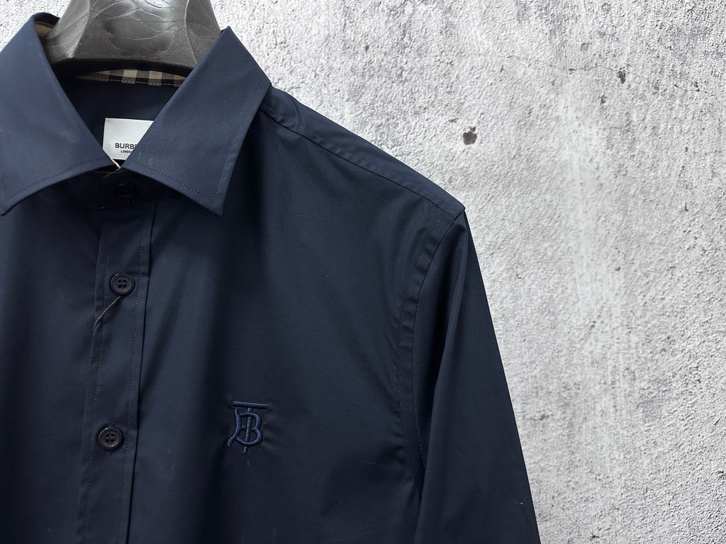 Navy button-up shirt collar and front placket with chest logo