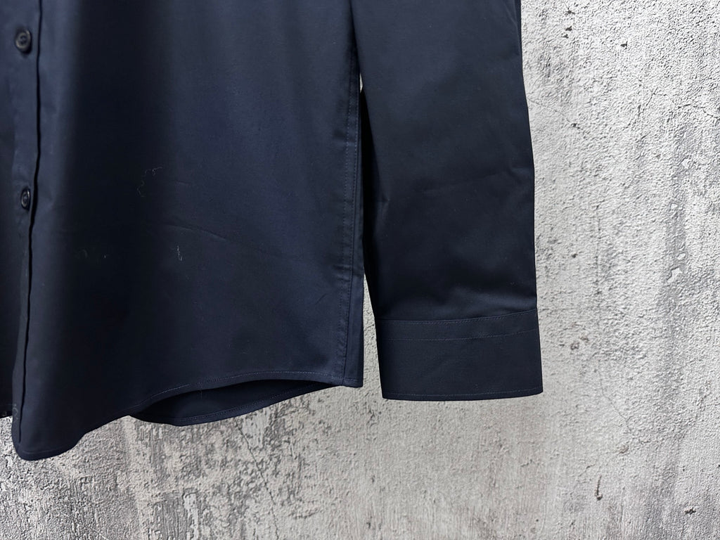 Navy long-sleeve button-up shirt hem with side seam and cuff edge