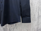 Navy long-sleeve button-up shirt hem with side seam and cuff edge