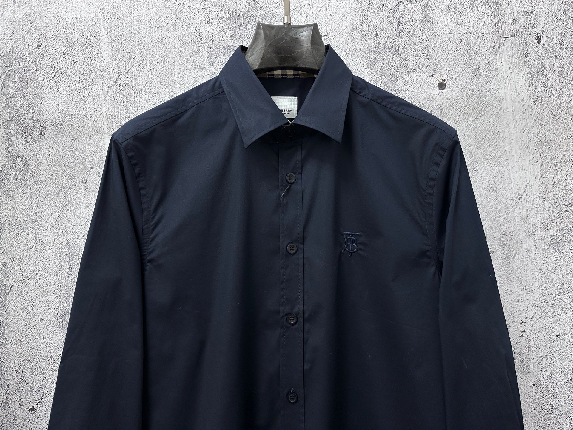 Navy long-sleeve button-up shirt, chest logo and four-button front