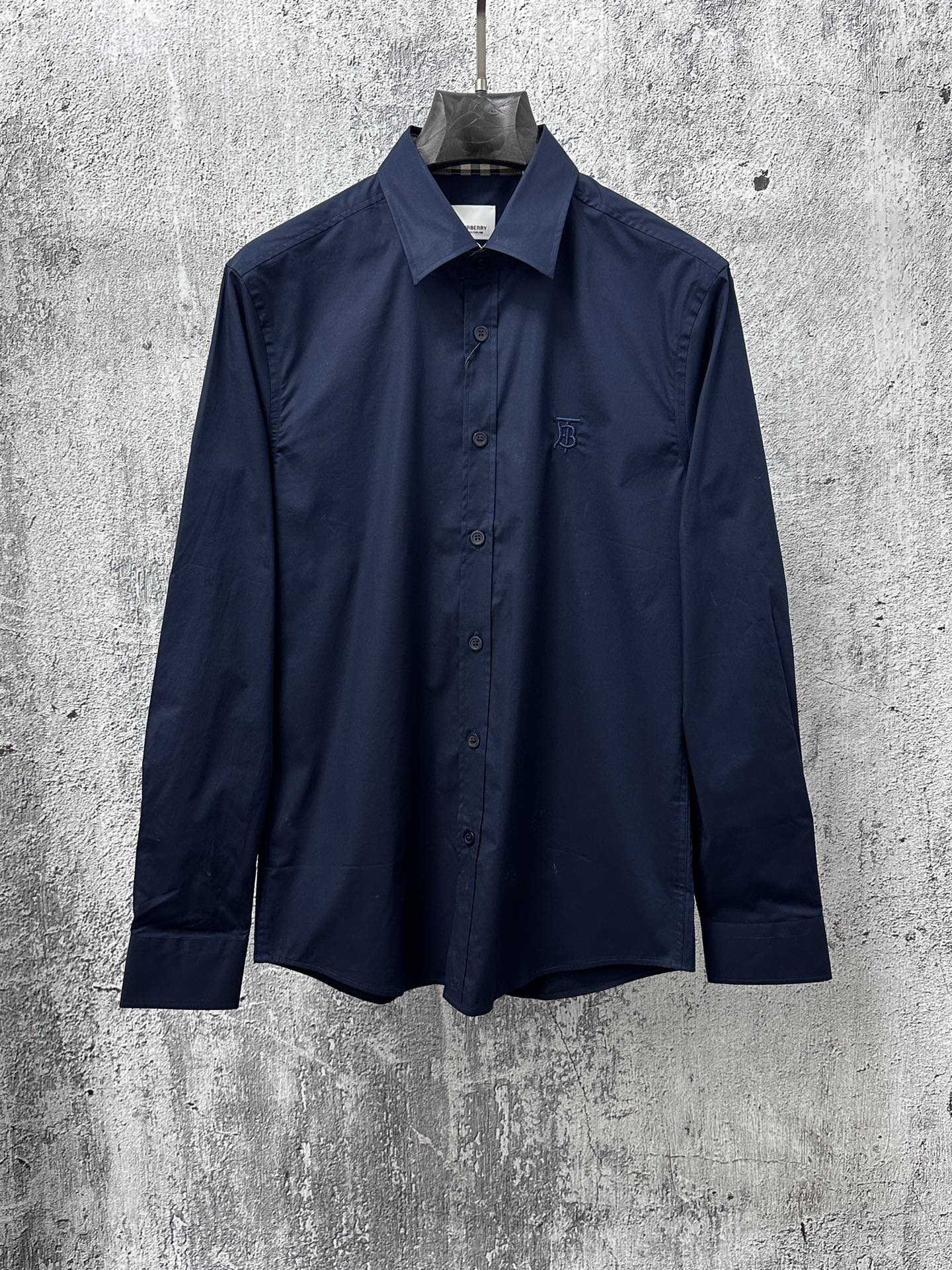 Navy long-sleeve button-up shirt, front button placket and chest logo