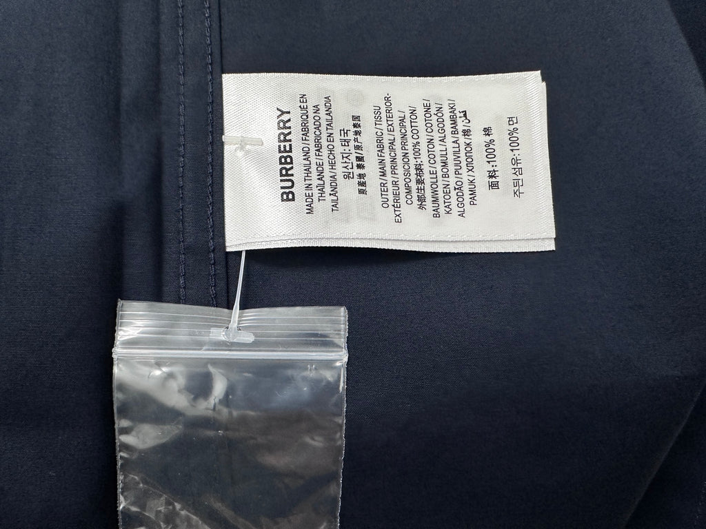 Burberry clothing label tag on dark navy shirt with care instructions