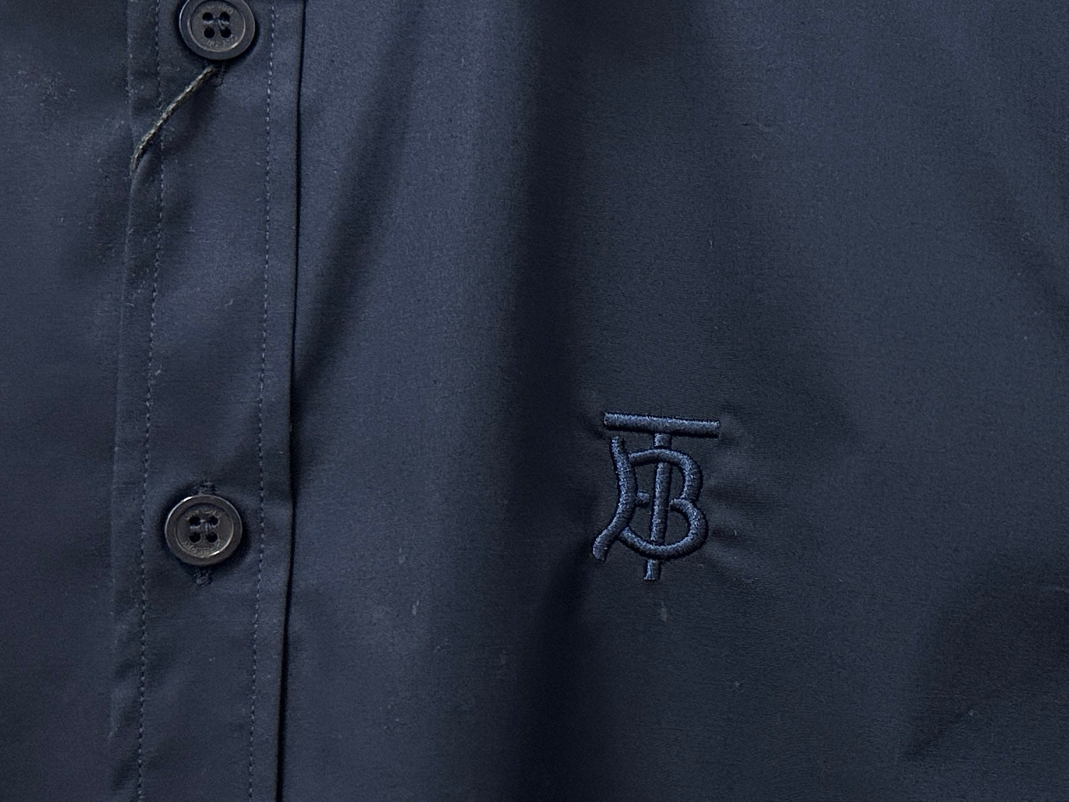 Navy shirt fabric with button at placket and embroidered B logo