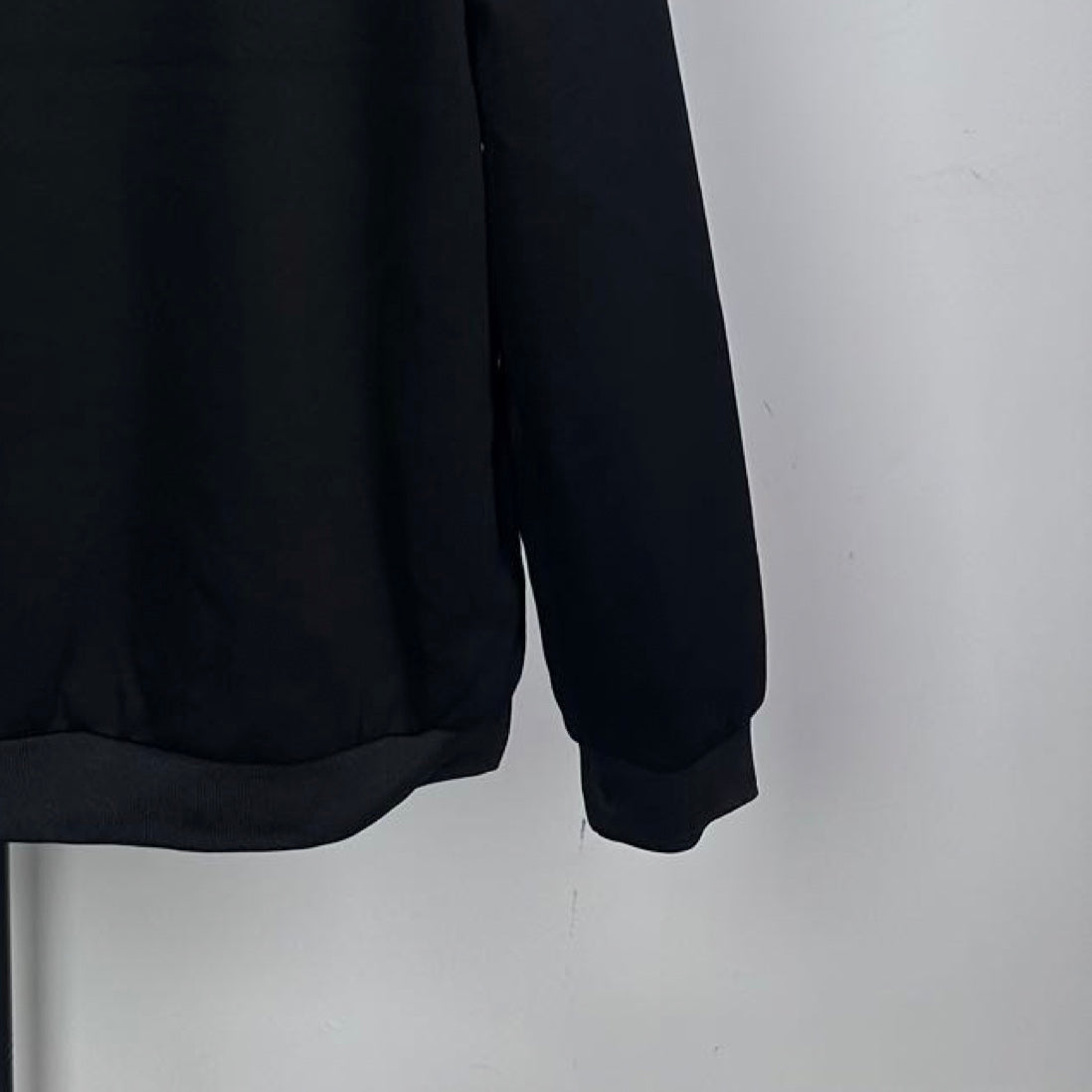 Long dark coat hem and long sleeve cuff