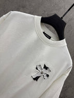 White short-sleeve T-shirt neckline detail with small cross graphic
