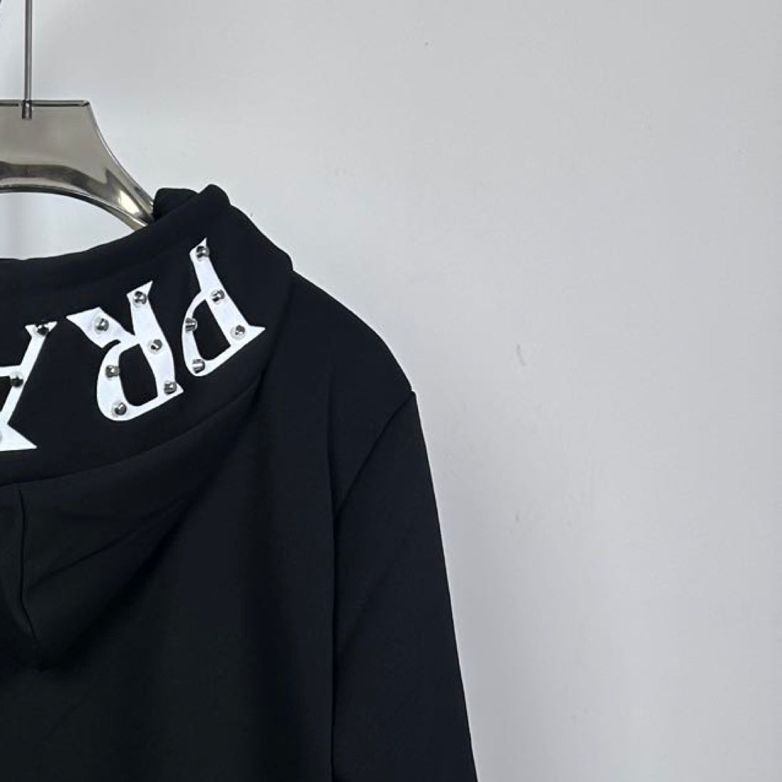 Black Prada hoodie with drawstring hood and large white graphic applique on back