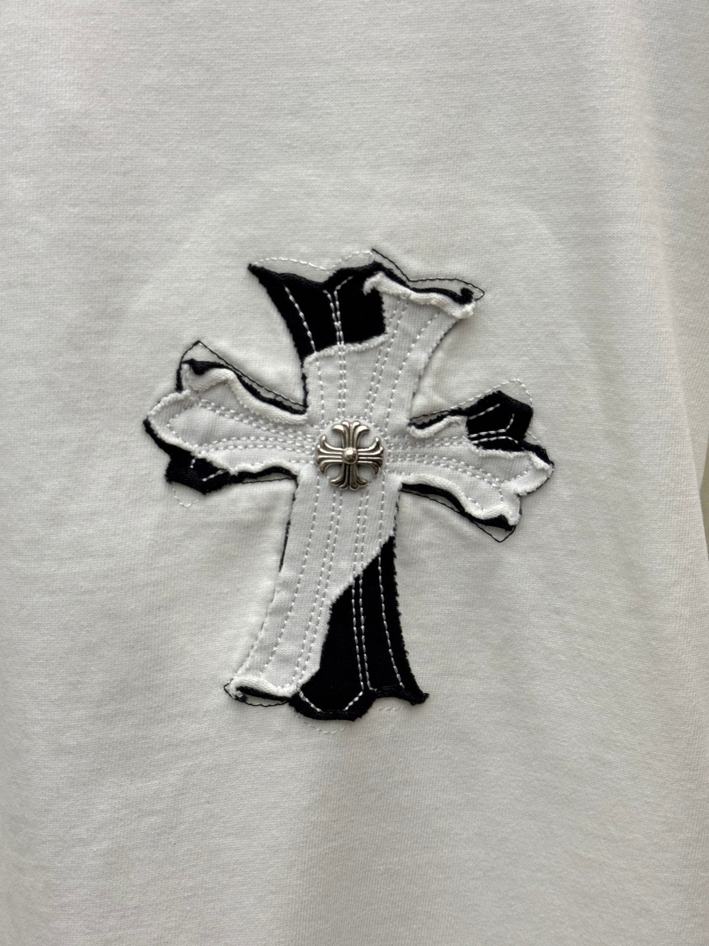 White T-shirt front cross applique in black and silver with central emblem