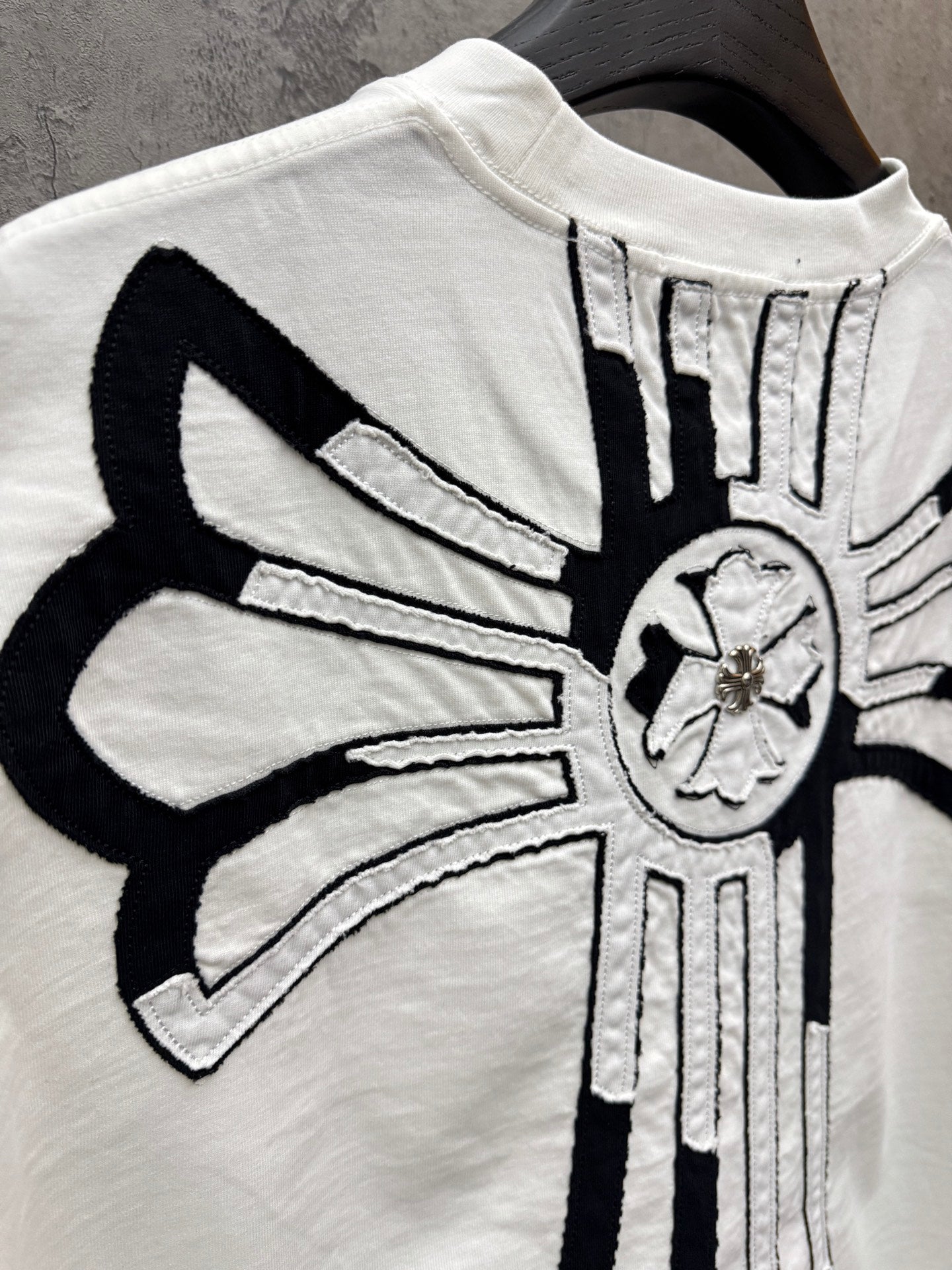 White T-shirt back close-up with crossburst graphic and circular emblem
