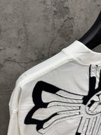 White T-shirt shoulder and sleeve with large black crossburst graphic detail