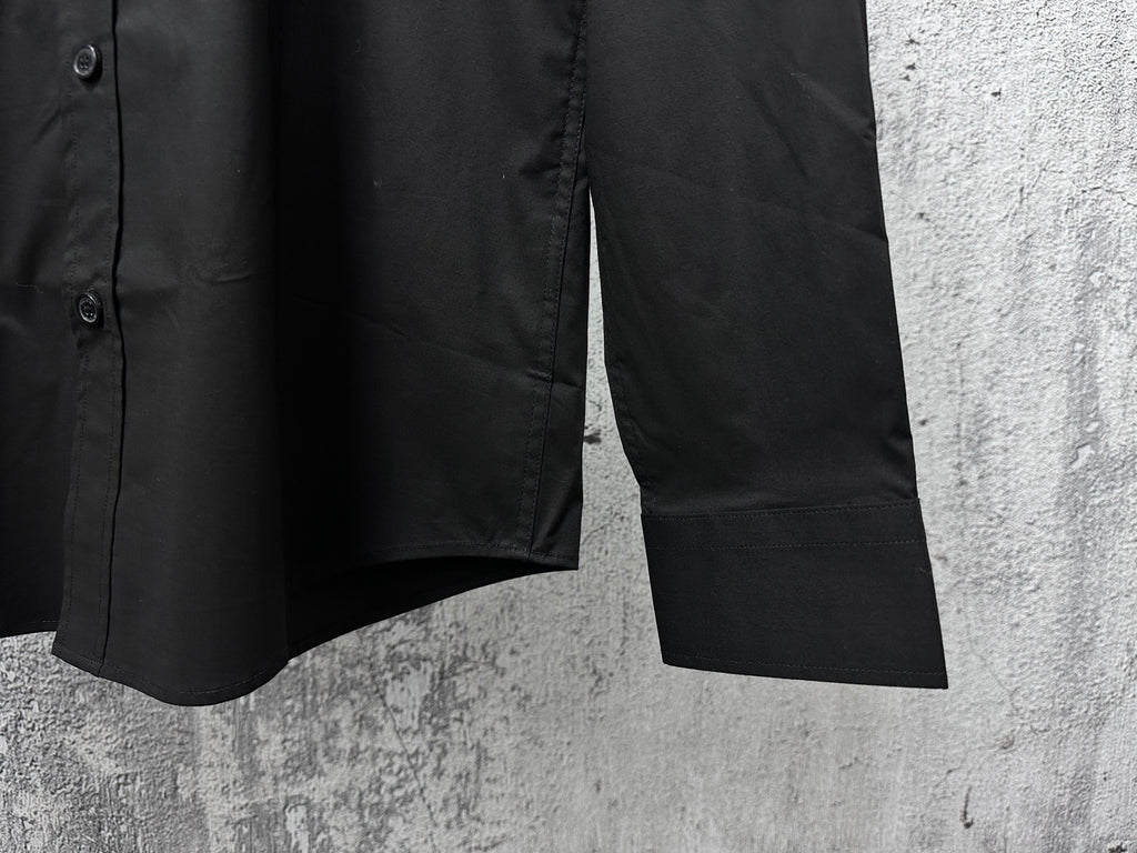 Black button-up shirt sleeve cuff with stitched hem