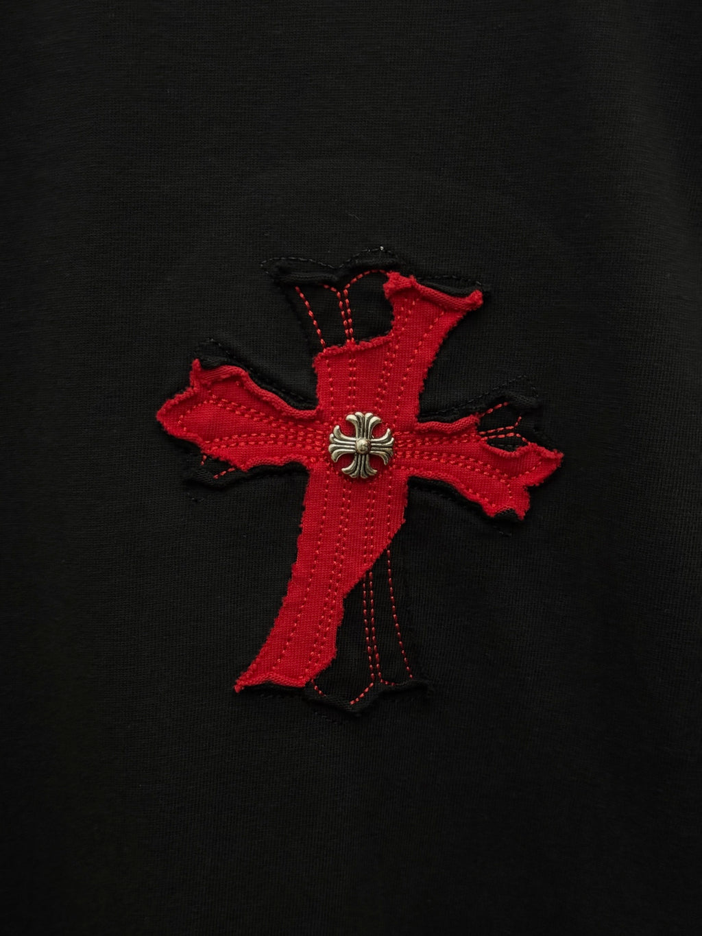 Red cross applique with fleur-de-lis detail on black T-shirt fabric