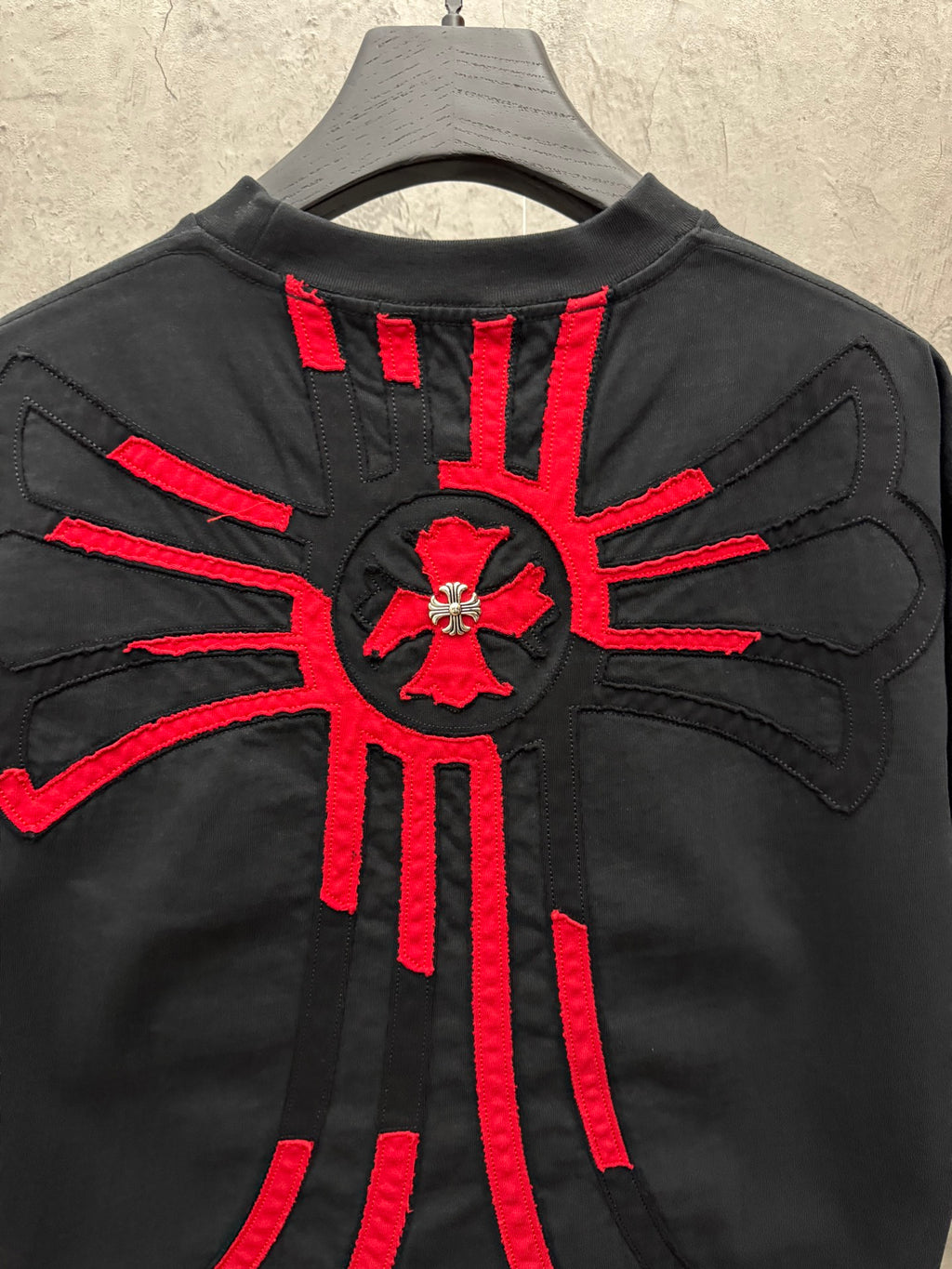 Black T-shirt back with large red radial cross graphic and applique