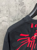 Black T-shirt shoulder and back with red radial cross graphic detail