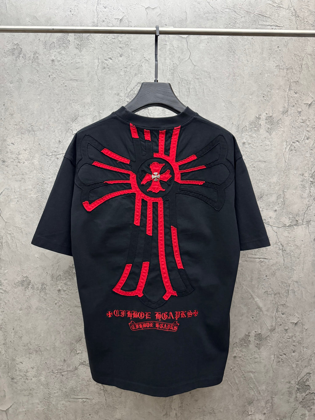 Dark navy short-sleeve T-shirt with large red cross sunburst graphic on back