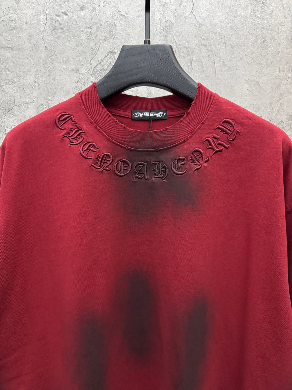 Red short-sleeve T-shirt with embroidered chest lettering near collar