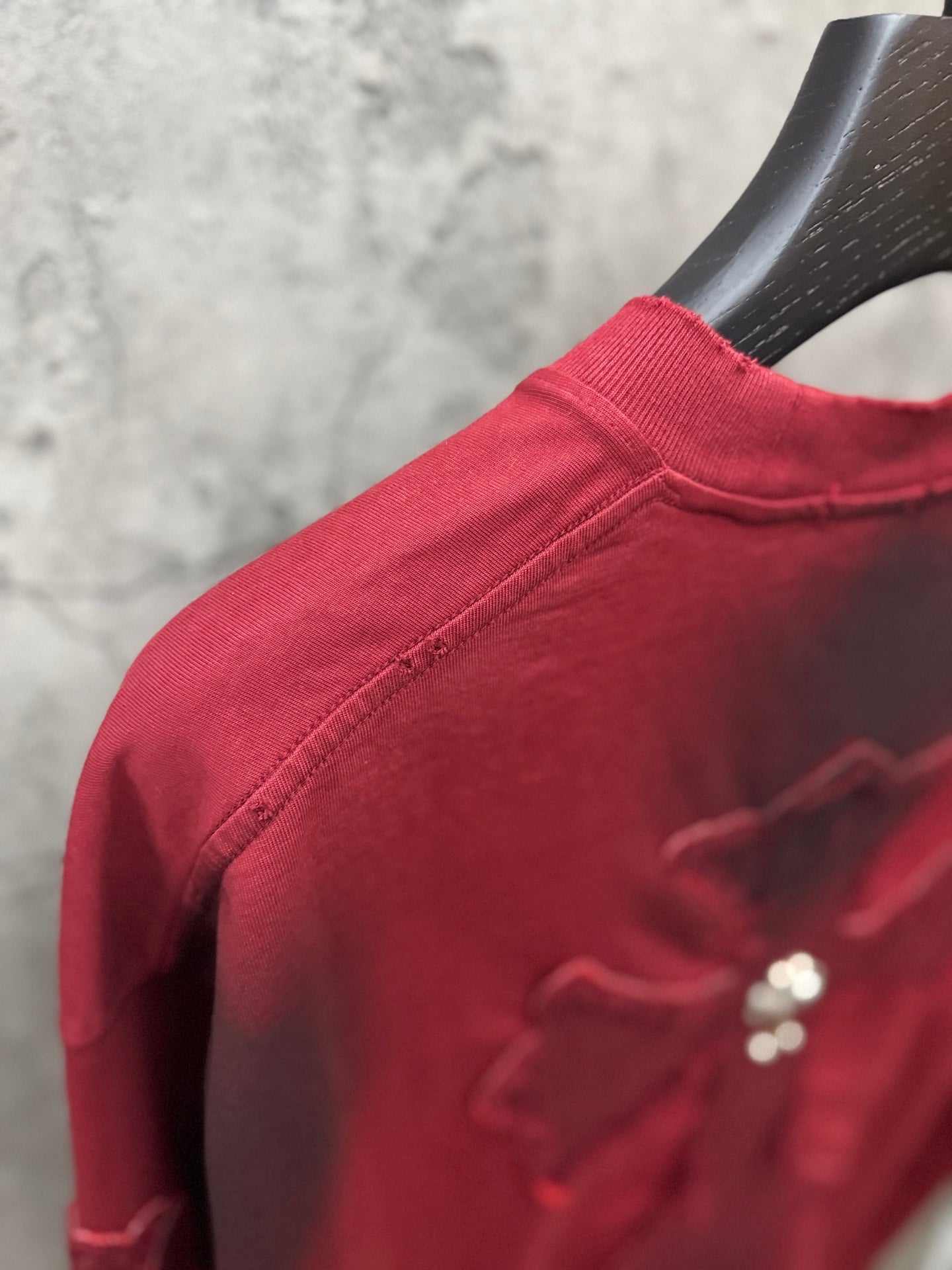 Red T-shirt shoulder detail with crew neck and visible seam stitching