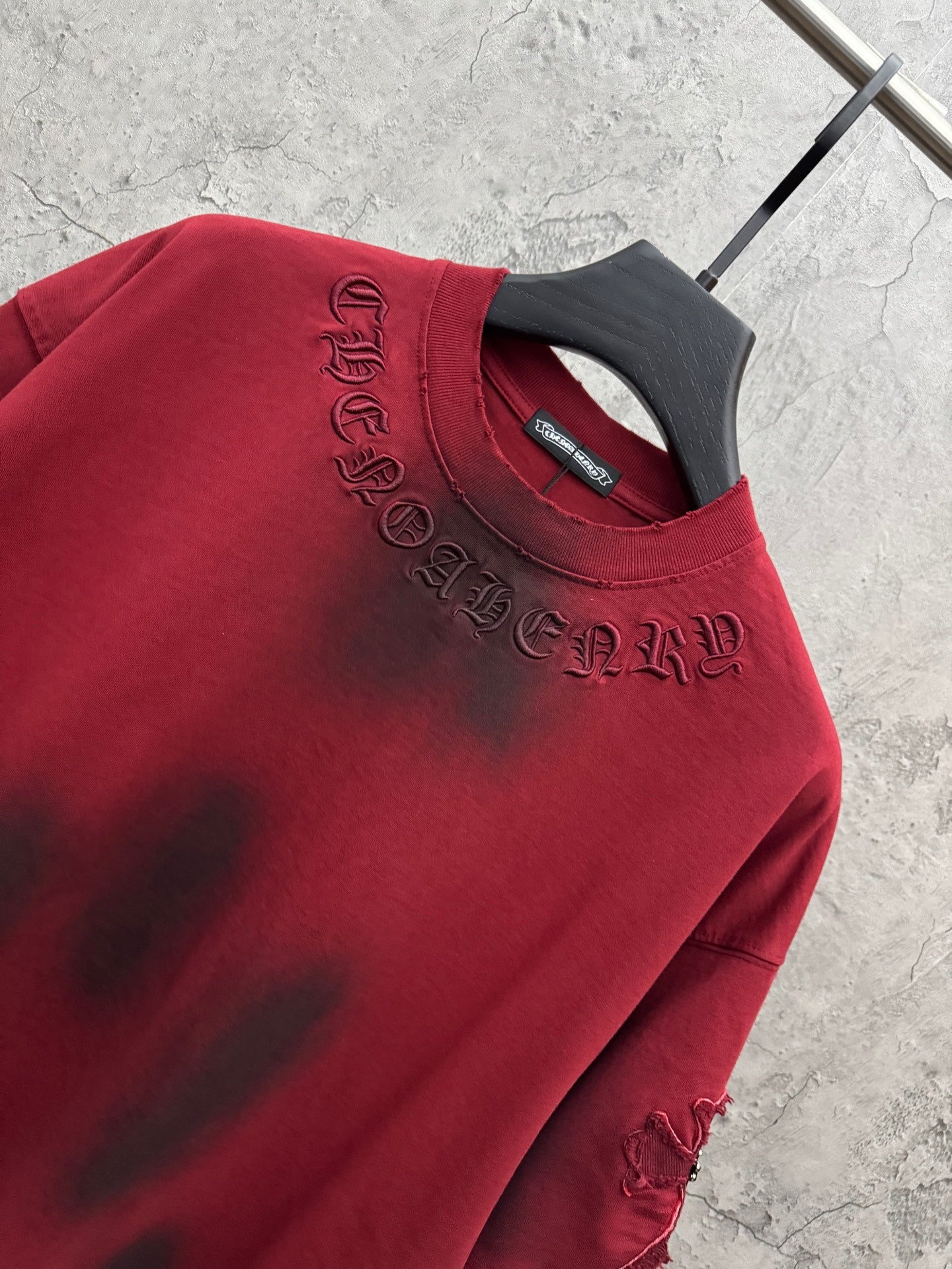 Red T-shirt close-up with embroidered neckline text and crew neck