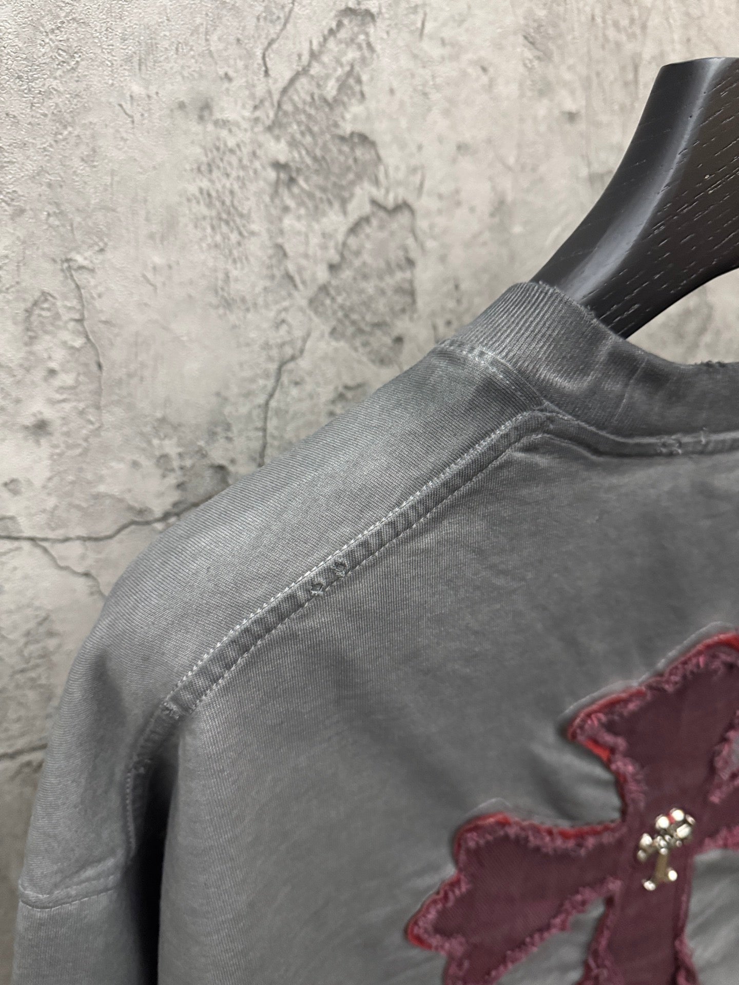 Gray short-sleeve T-shirt shoulder seam with partial burgundy cross patch