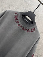 Grey crewneck T-shirt with maroon embroidered text across the chest