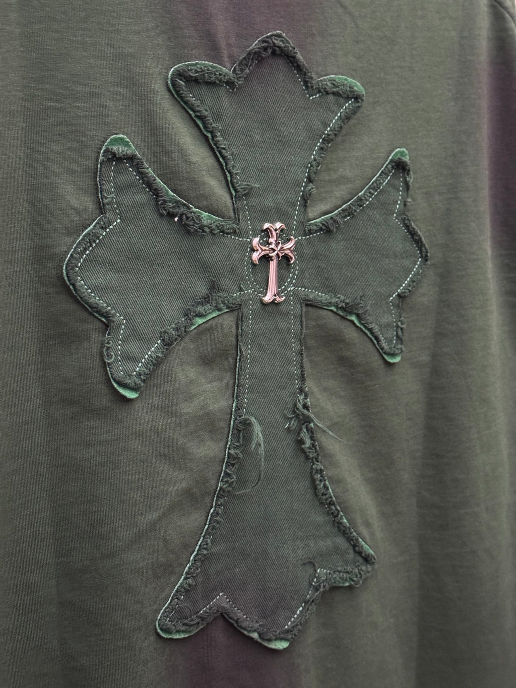 Green short-sleeve T-shirt close-up of embroidered angel cross emblem