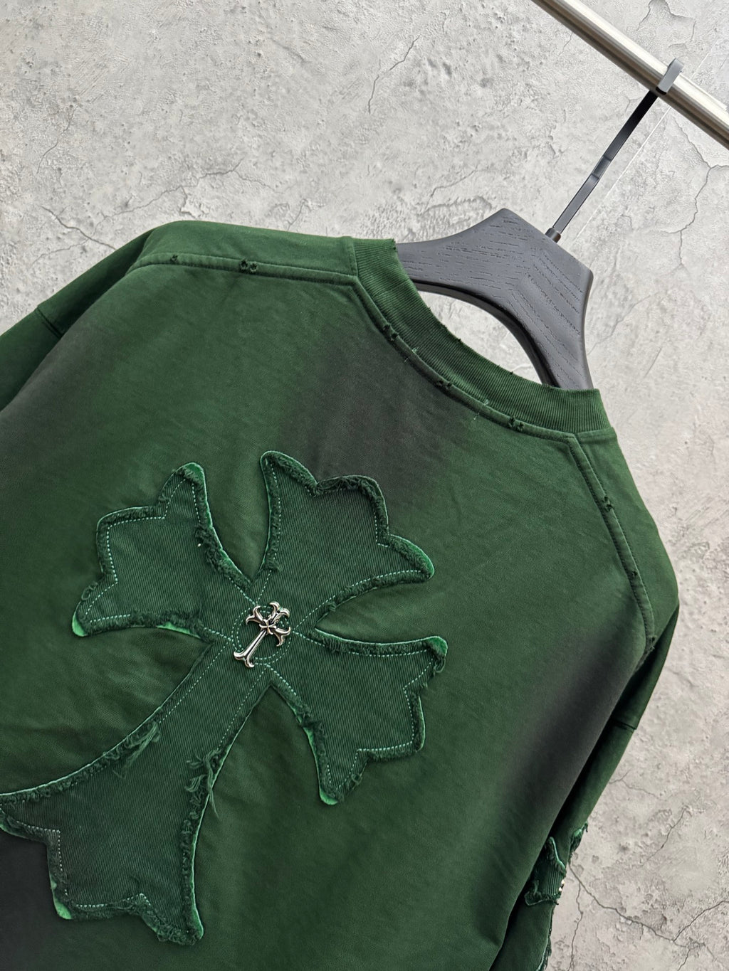 Green T-shirt with large stitched cross applique on the chest