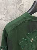 Green T-shirt with embroidered cross detail on the shoulder