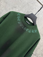 Green short-sleeve T-shirt close-up of collar and arched embroidered text