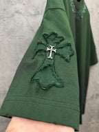 Green short-sleeve T-shirt close-up of sleeve with small embroidered angel cross