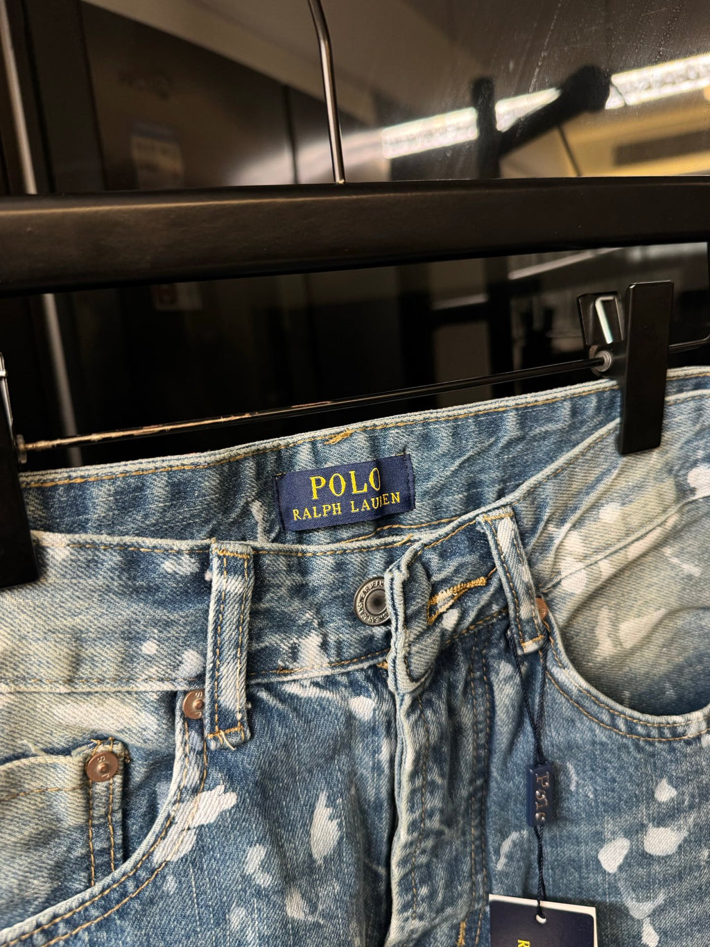 Light-wash denim jeans waistband with POLO Ralph Lauren logo and speckles
