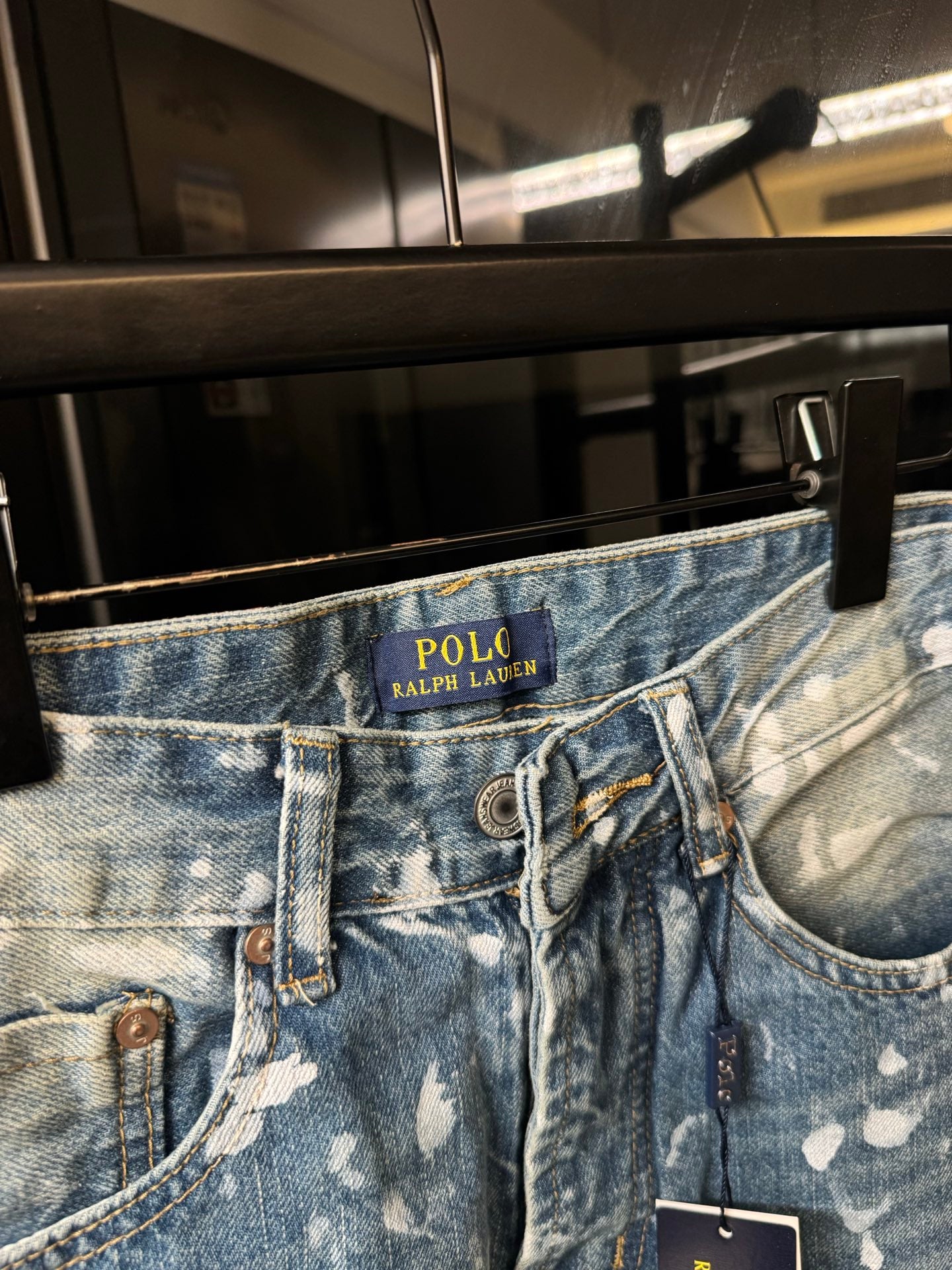 Light-wash denim jeans waistband with POLO Ralph Lauren logo and speckles