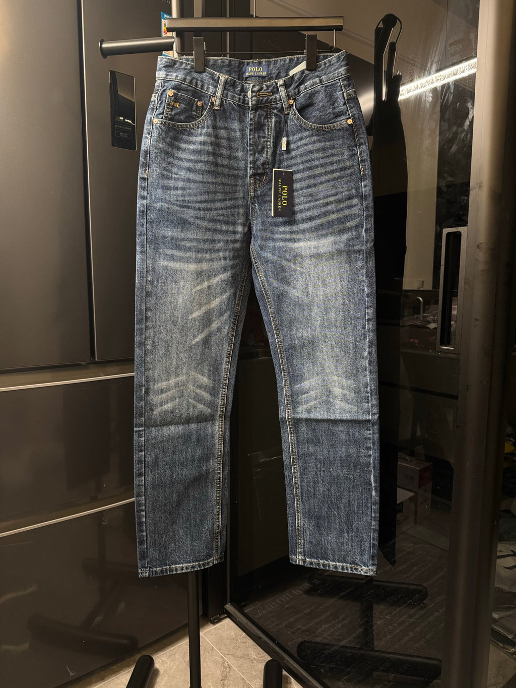 Light blue denim jeans with belt loops, button fly, and stitched front pockets