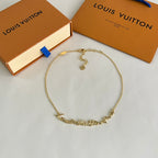 Gold-tone chain bracelet with engraved links and small charm details