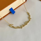 Gold-tone chain bracelet close-up with engraved nameplate and heart motif