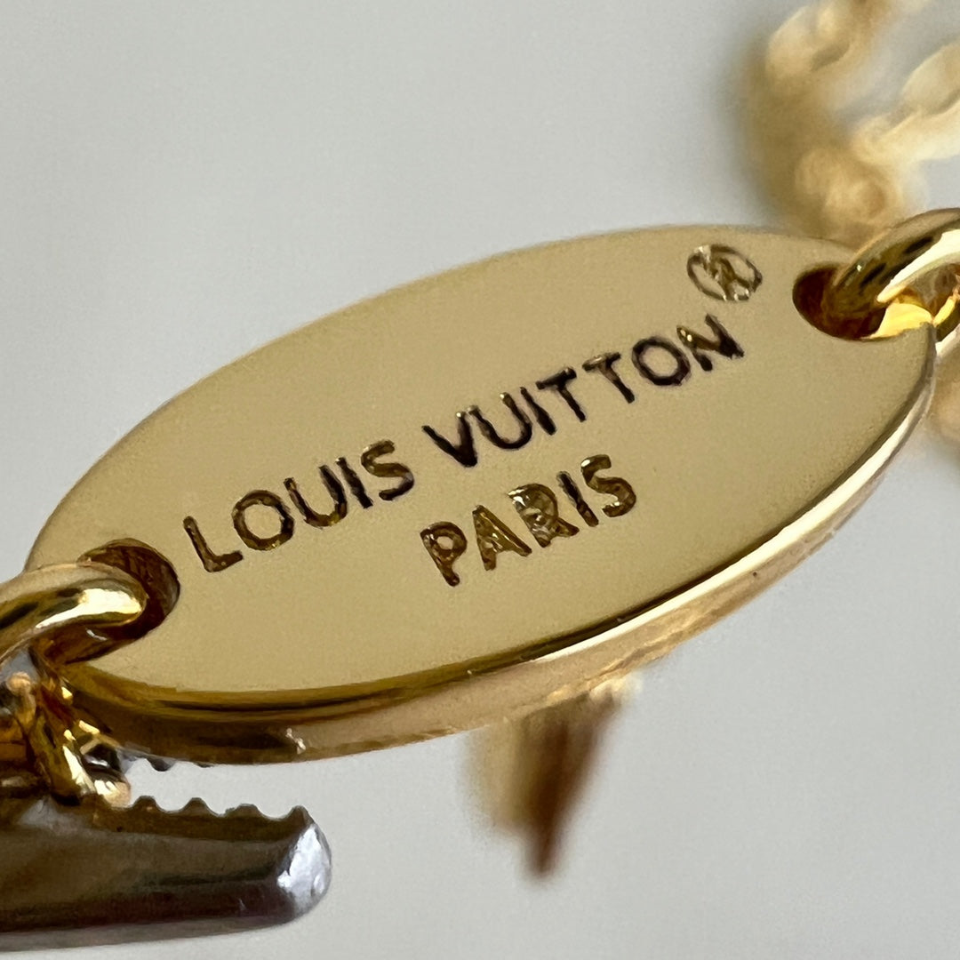 Gold-tone oval charm stamped Louis Vuitton and Paris 1915