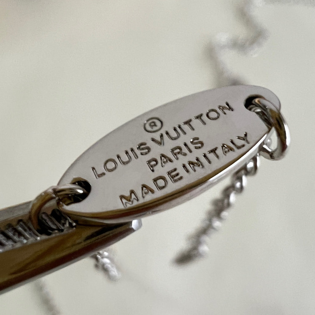 Louis Vuitton engraved clasp tag with 'LOUIS VUITTON', 'PARIS', and 'MADE IN ITALY'