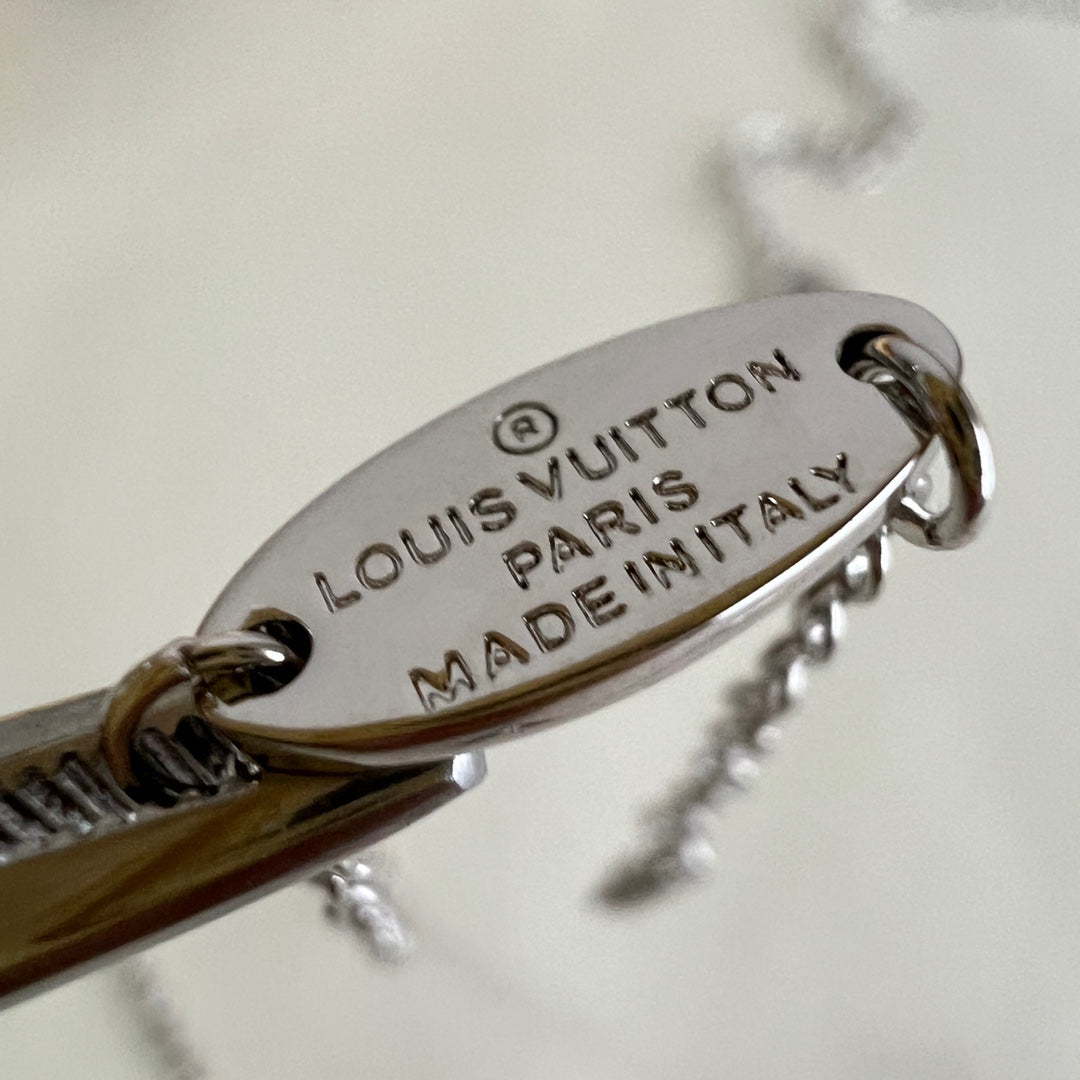 Louis Vuitton engraved clasp tag with 'LOUIS VUITTON', 'PARIS', and 'MADE IN ITALY'