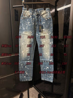 Distressed light-wash denim jeans with white speckle splatter, hanging front view