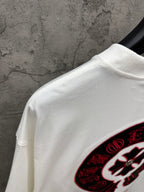 White T-shirt shoulder and collar with partial red-and-black circular logo