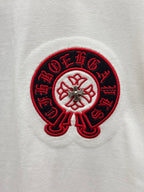 Red-and-black embroidered circular logo on white T-shirt