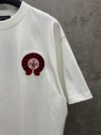 White crew-neck T-shirt with small red-and-black logo on chest, short sleeves