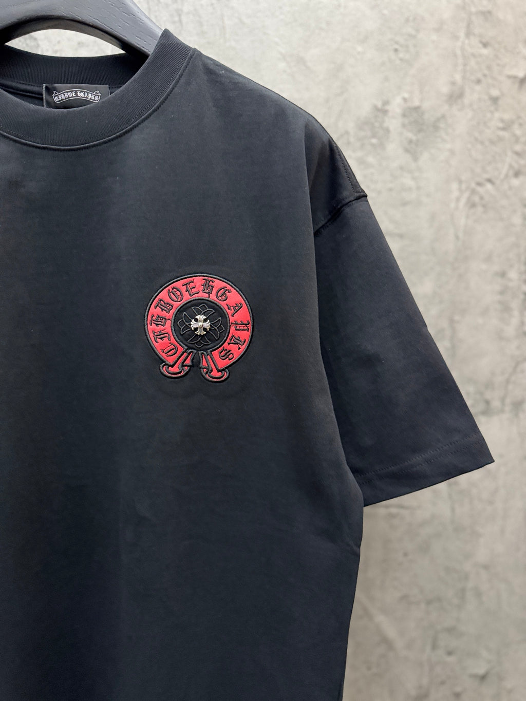 Black short-sleeve T-shirt with small red circular chest logo