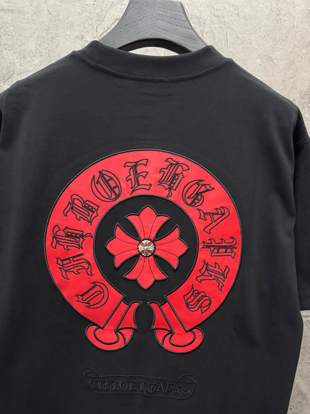Black short-sleeve T-shirt with large red back flower graphic logo