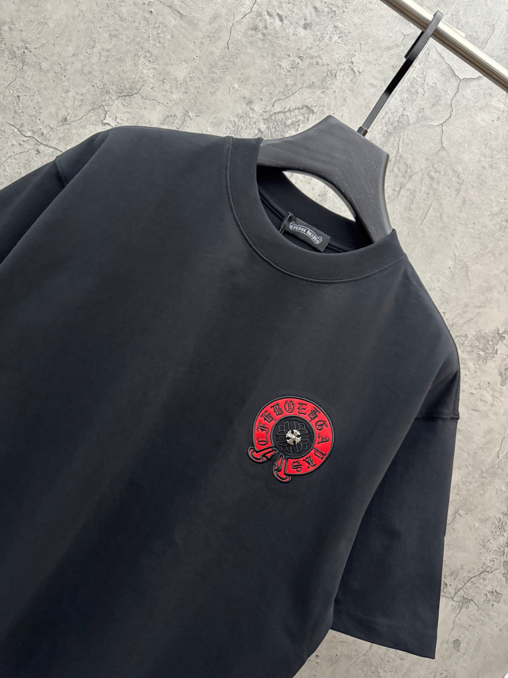 Black short-sleeve T-shirt with crew neck and small red chest logo