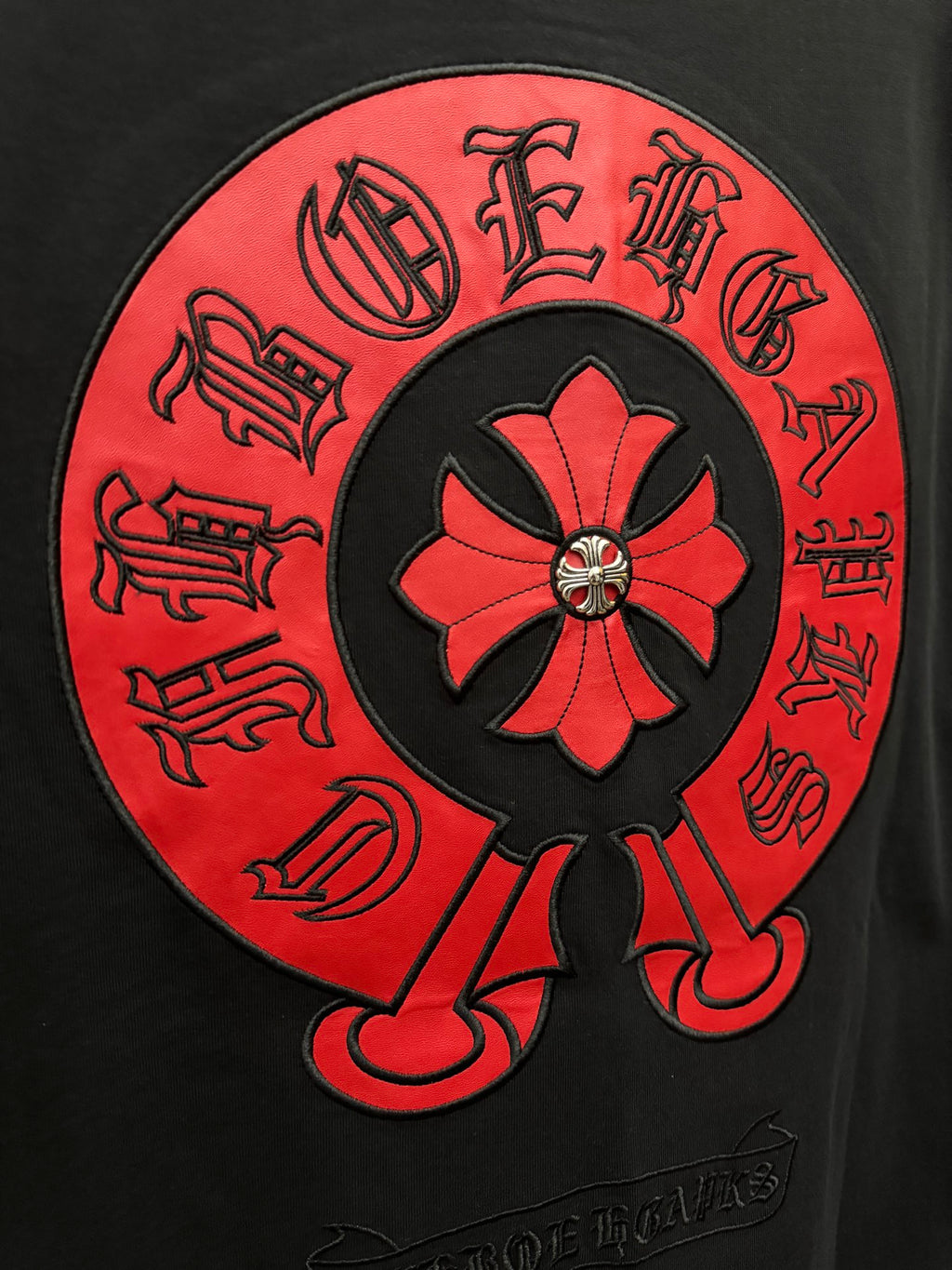 Black short-sleeve T-shirt close-up of red circular back graphic logo