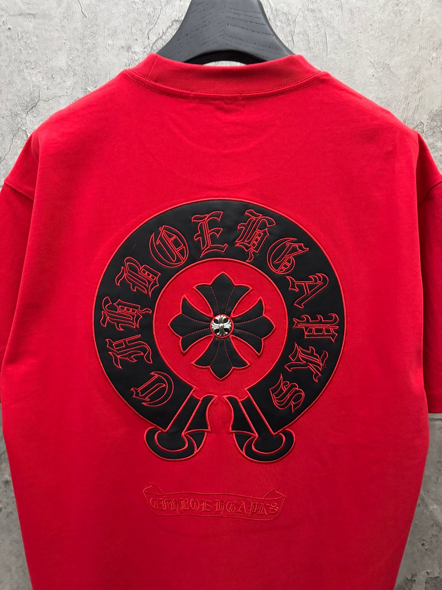 Red short-sleeve T-shirt featuring large back circular flower emblem.