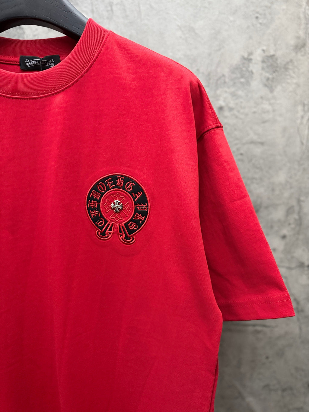 Red T-shirt with black circular chest logo and short sleeves