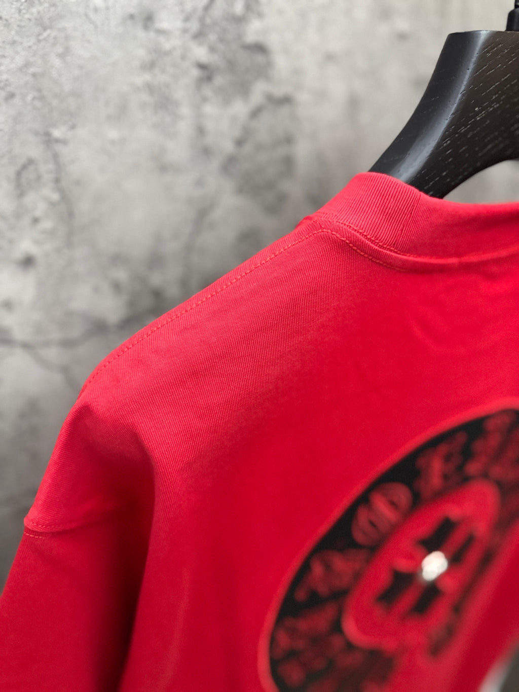 Red T-shirt sleeve close-up with black logo and crew neckline