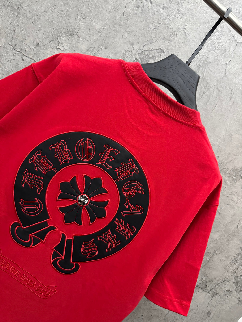 Red T-shirt with large back circular emblem, crew neck and sleeve.
